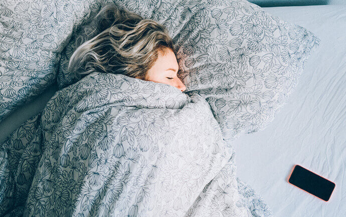 девушка-спит-в-кровати-укрывшись-одеялом-во-сне-улучшается-метаболизм