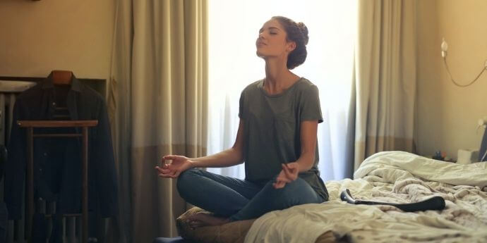 Девушка-медитирует-на-кровати-как-повысить-женскую-энергетику-коучинг-Лара-Серебрянская
